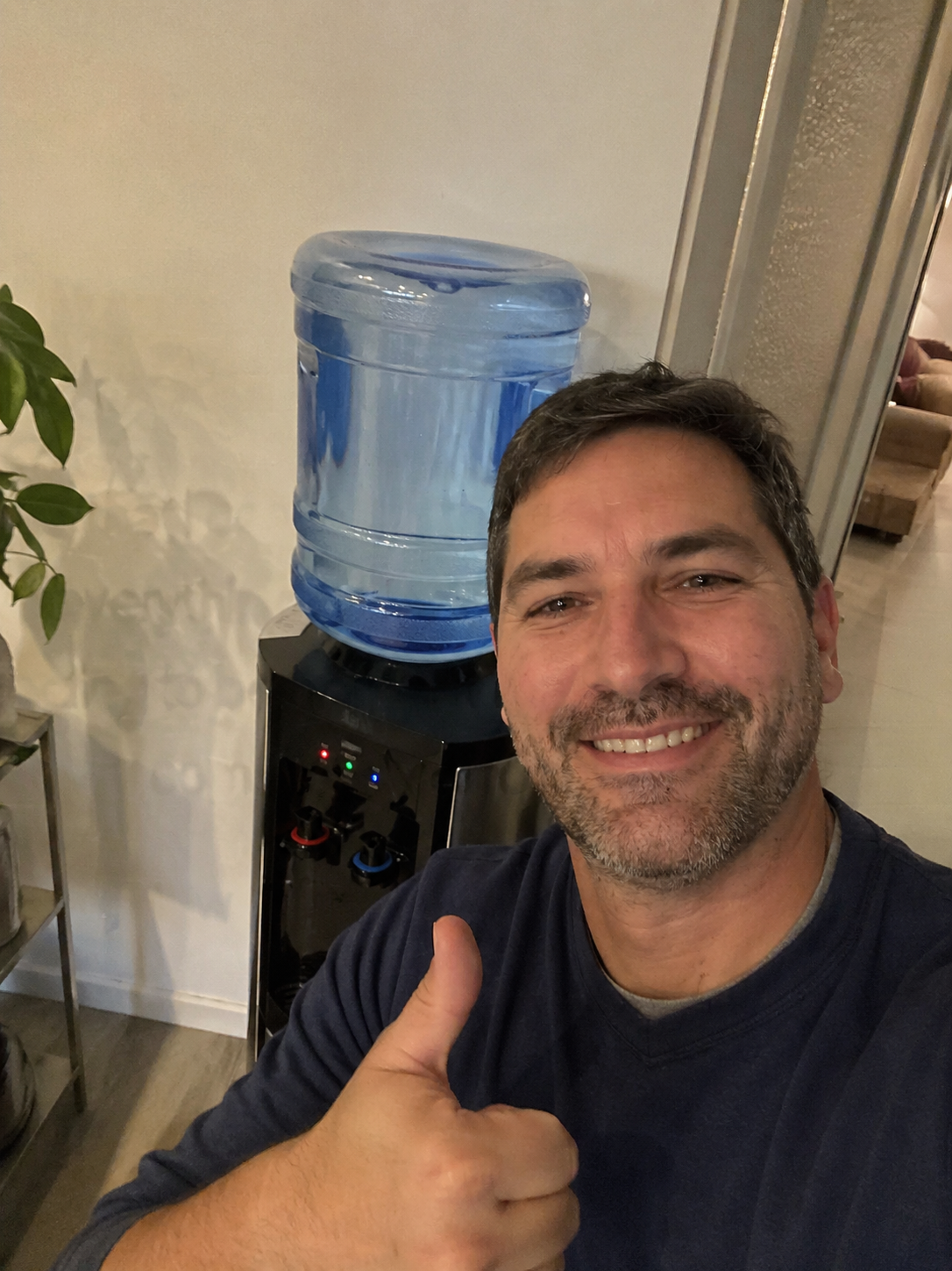 James giving a thumbs up next to his home water dispenser.
